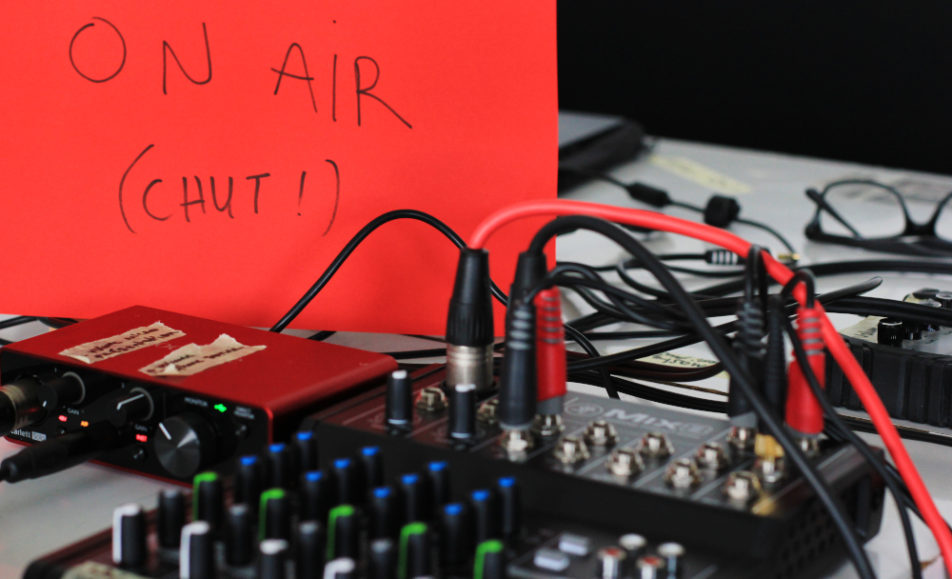 Table radio avec carton sur lequel est écrit "on air chut"avec câbles