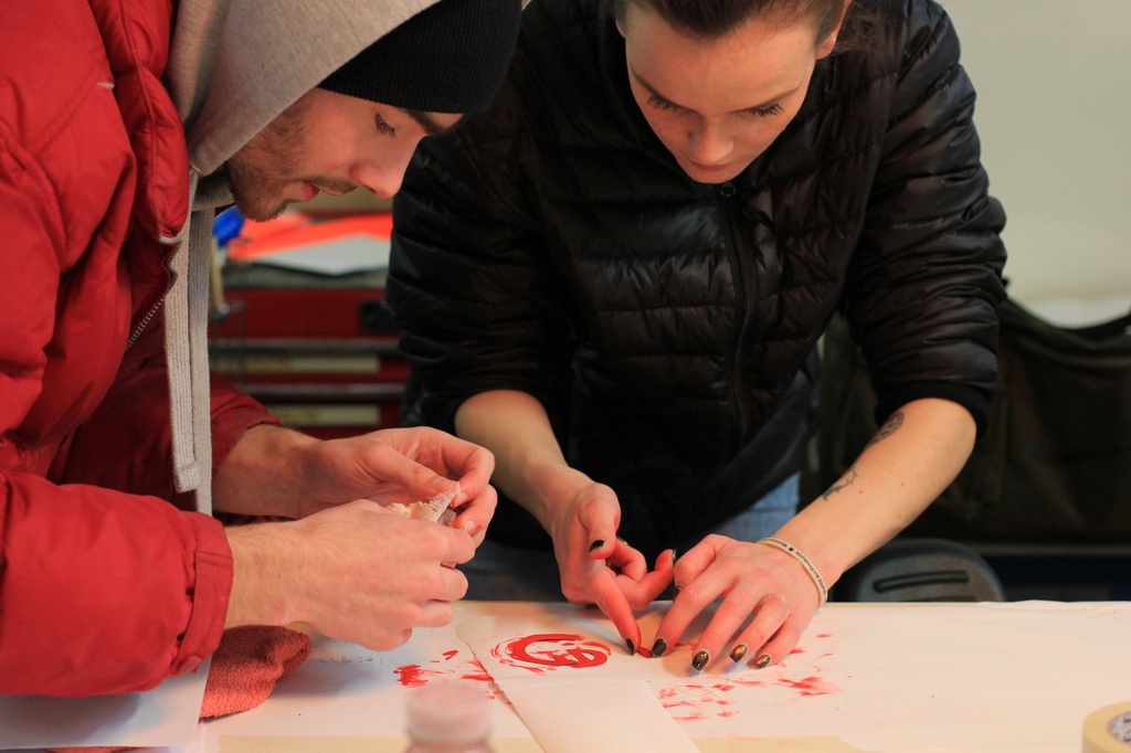 deux personnes penchées sur une table manipulent des morceaux de papier