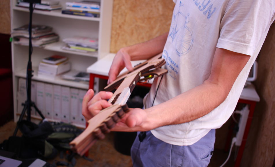 gros plan sur le buste de quelqu'un qui tient une guitare en bois dans ces mains