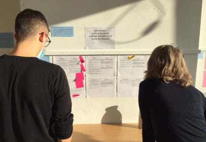 des personnes regardent des notes sur le mur