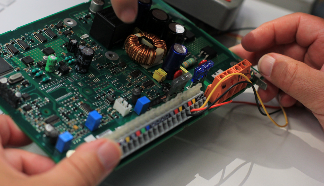 gros plan sur des mains tenant un circuit électronique