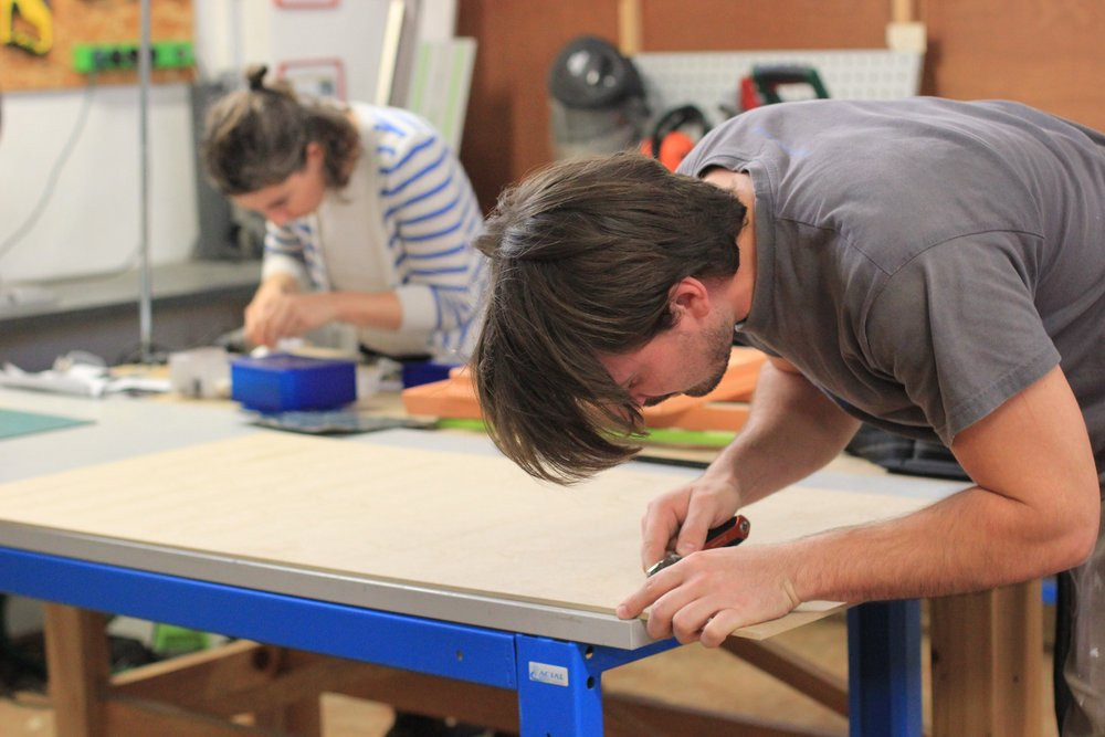 Atelier à Plateforme C, PiNG des perosnnes travaillent sur un établi dans un fablab