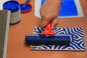 détail d'une main qui utilise un rouleau de peinture