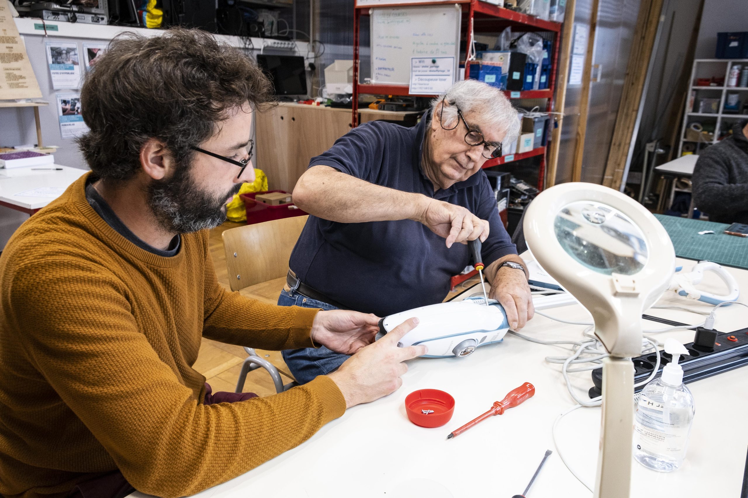 des personnes réparent du matériel dans un atelier