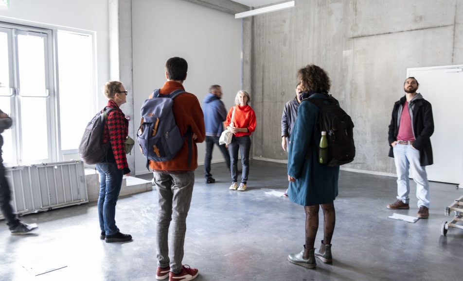 des perosnnes visitent un bâtiment brut