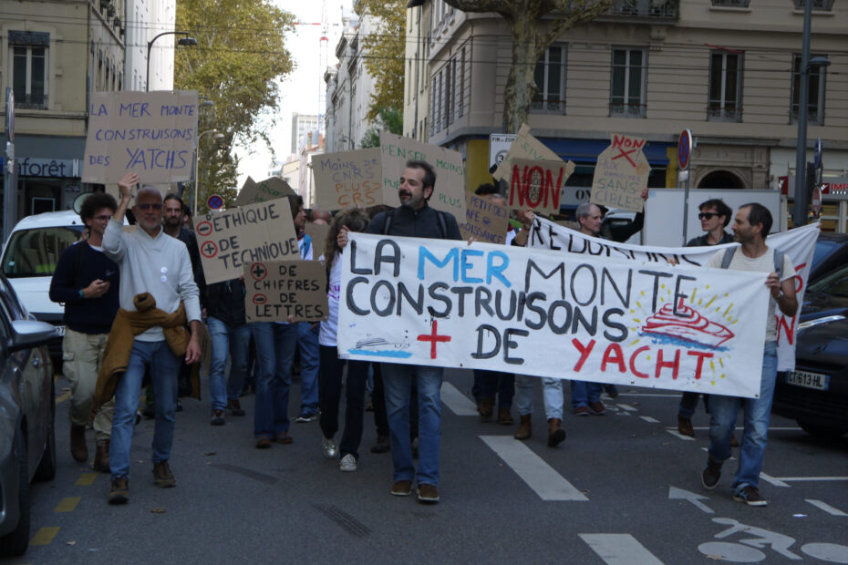 manifestation_derision Photo d'une manifestation avec des pancartes ironiques comme "la mer monte construisons plus de yacht"